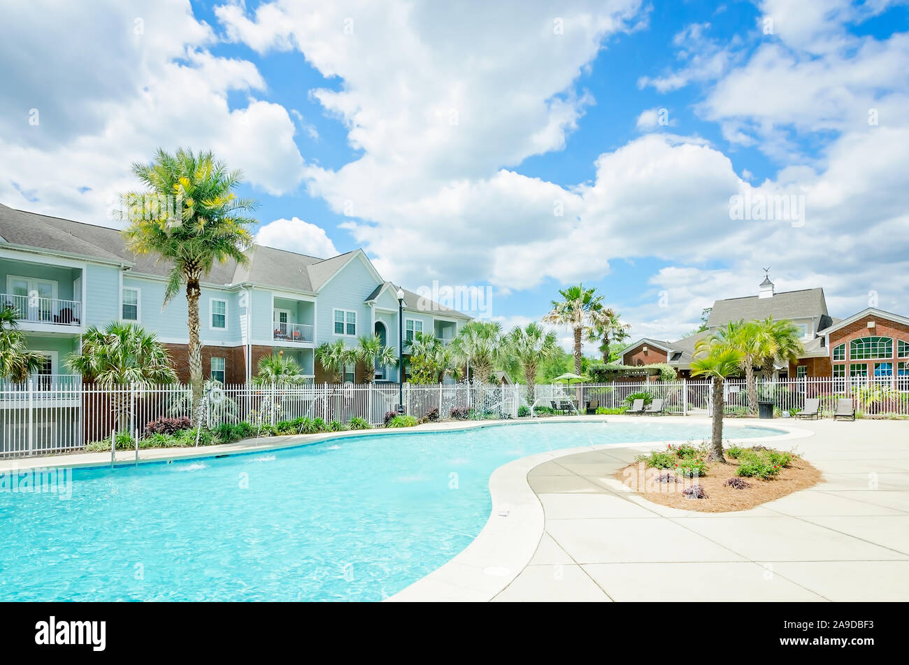 A large, curvy built-in zero entry swimming pool is a focal point for residents at Cypress Cove Apartment Homes in Mobile, Alabama. Stock Photo