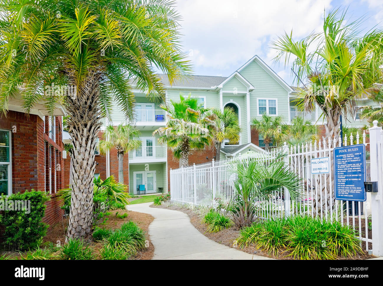 A curving sidewalk leads residents between the swimming pool and