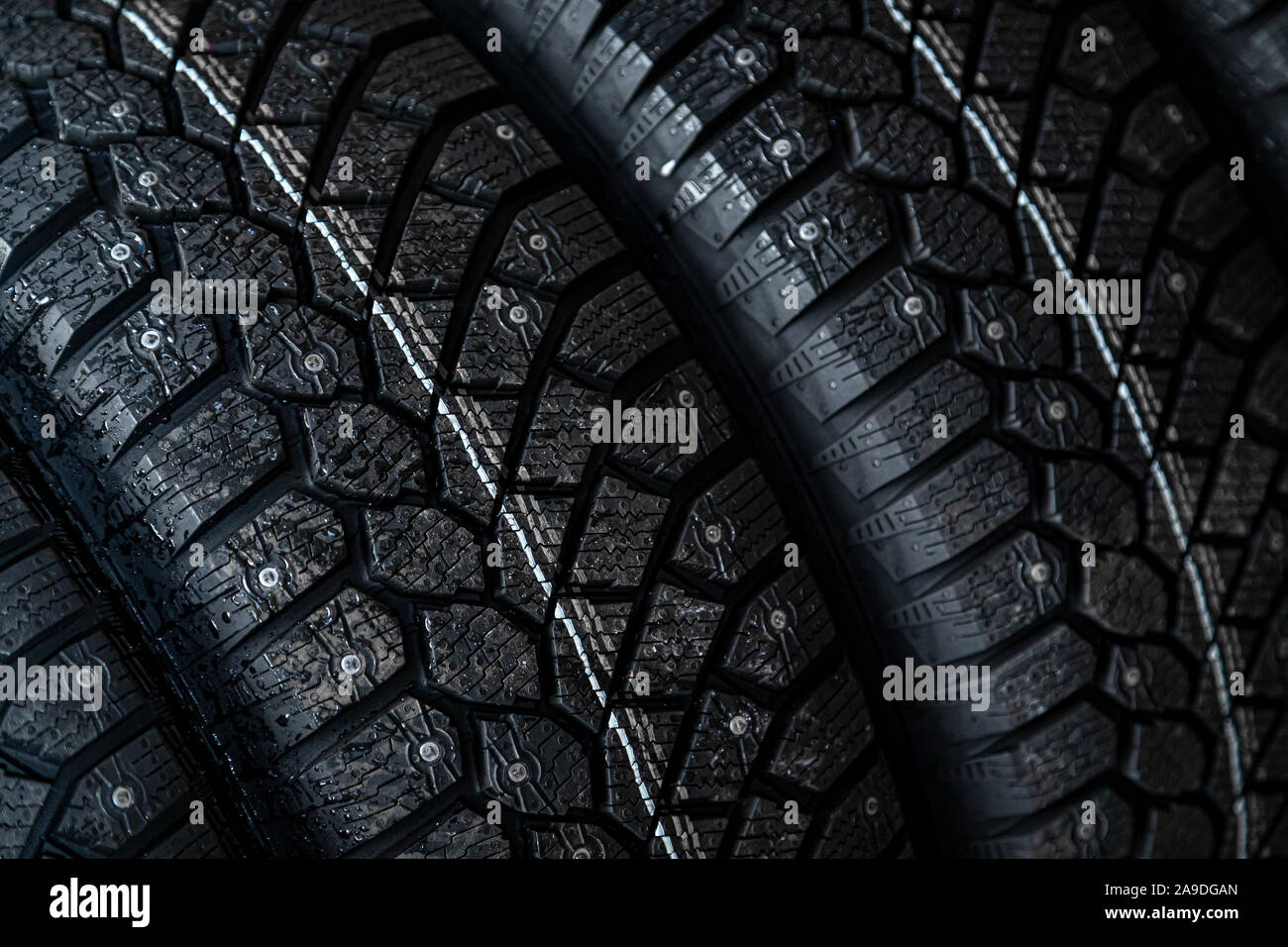 Closeup black new studded tires for winter driving in a car Stock