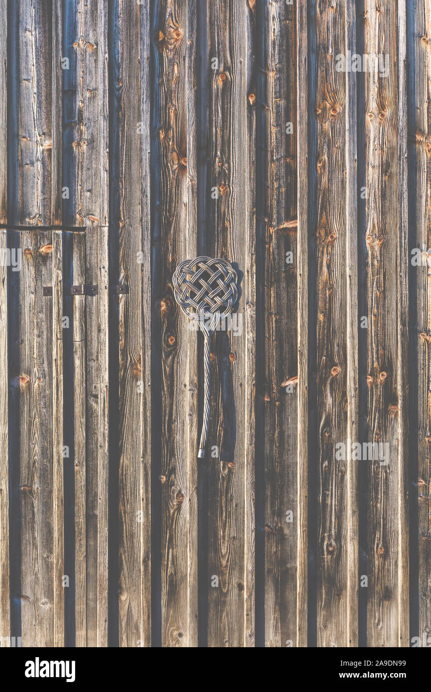 A carpet beater hanging on a wooden wall Stock Photo