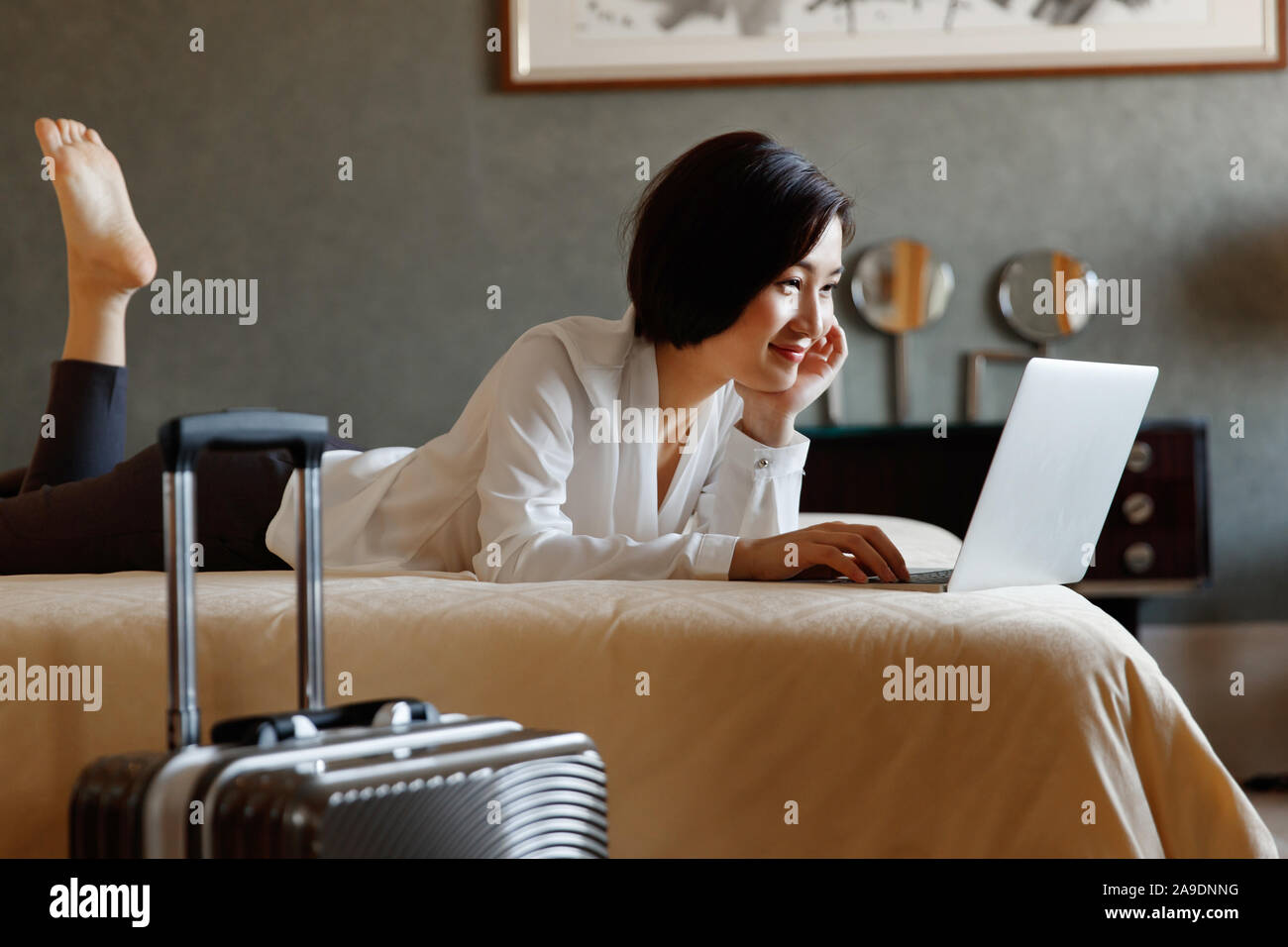 The young woman lying on the bed with the computer Stock Photo - Alamy
