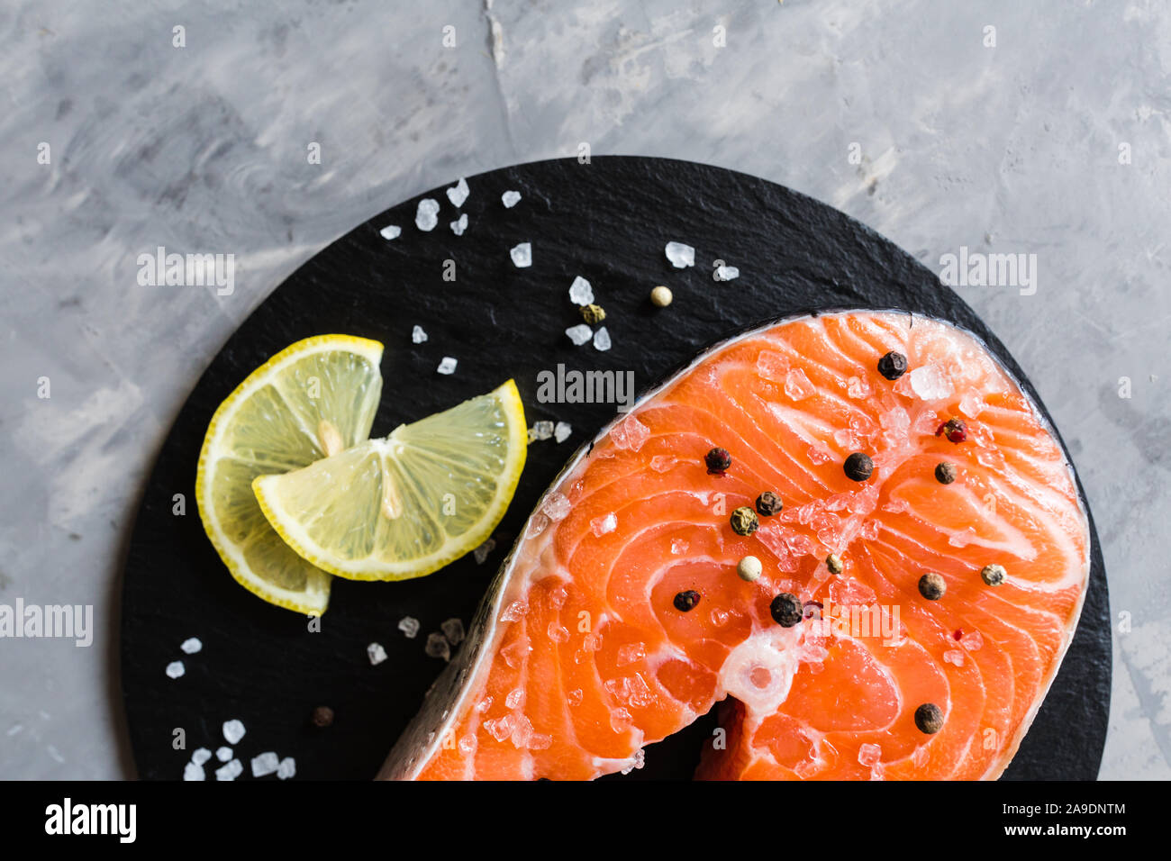 Fresh raw salmon fish steak with spices on dark stone background ...
