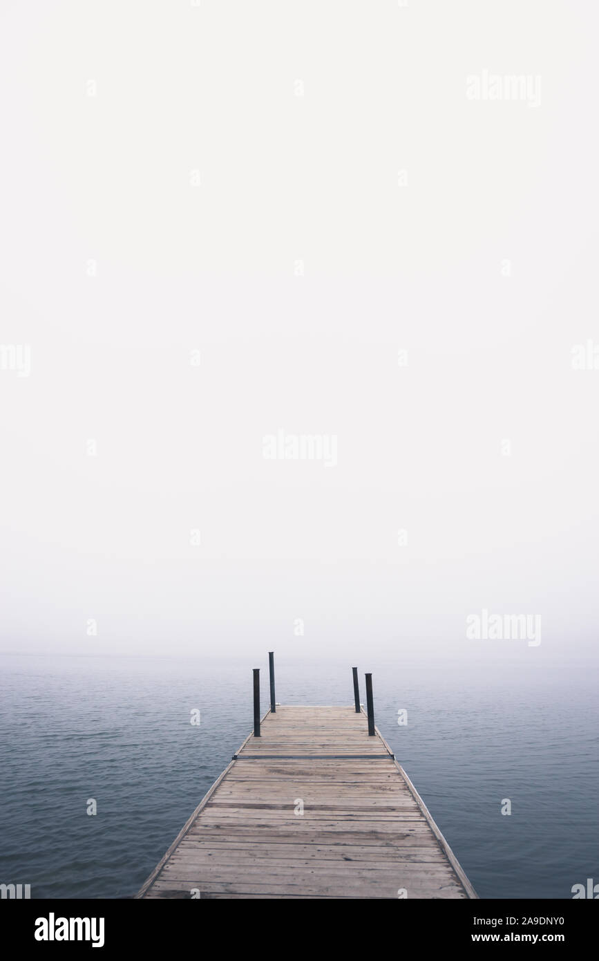 Dock on the lake in the fog during summer Stock Photo