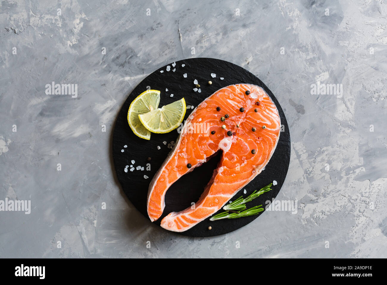 Fresh raw salmon fish steak with spices on dark stone background ...
