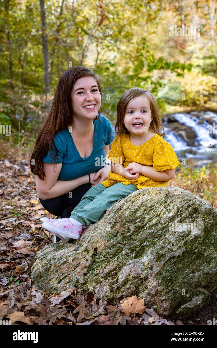 Mother and daughter in front of waterfall in a happy pose Stock Photo