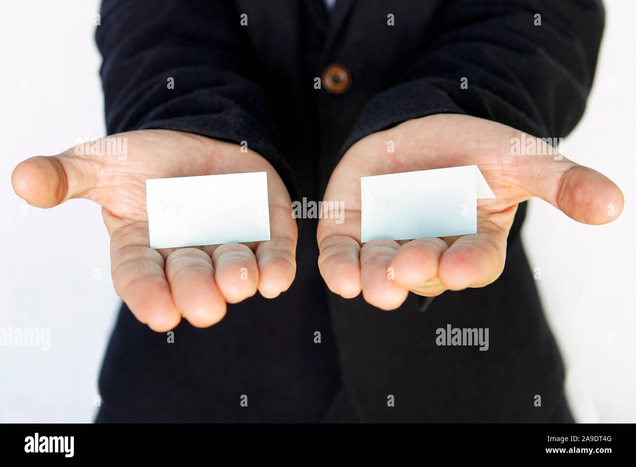 hands is holding a blue color papers with empty space for note. Offer a choice of 2 options. Stock Photo