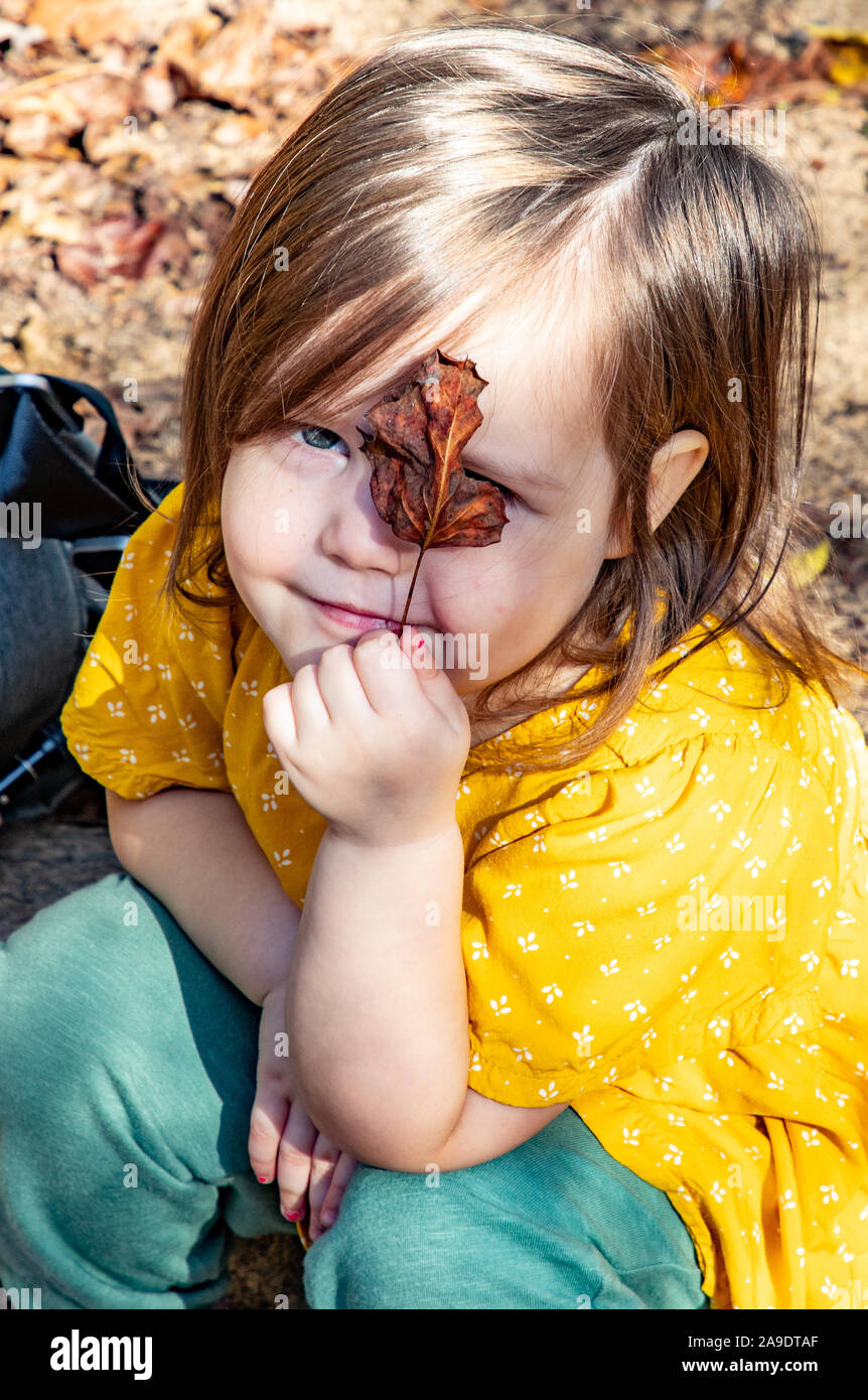 Toddler showing the leaf she found Stock Photo