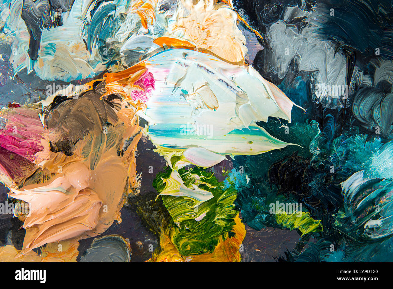 Oils paint spread on painter's palette. Mixing different colors of