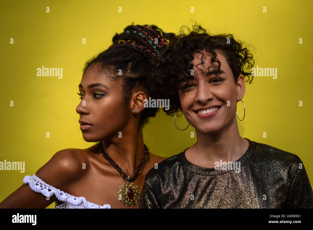 Two latin young women in the street; one looks at the camera, the other looks away, Cali
