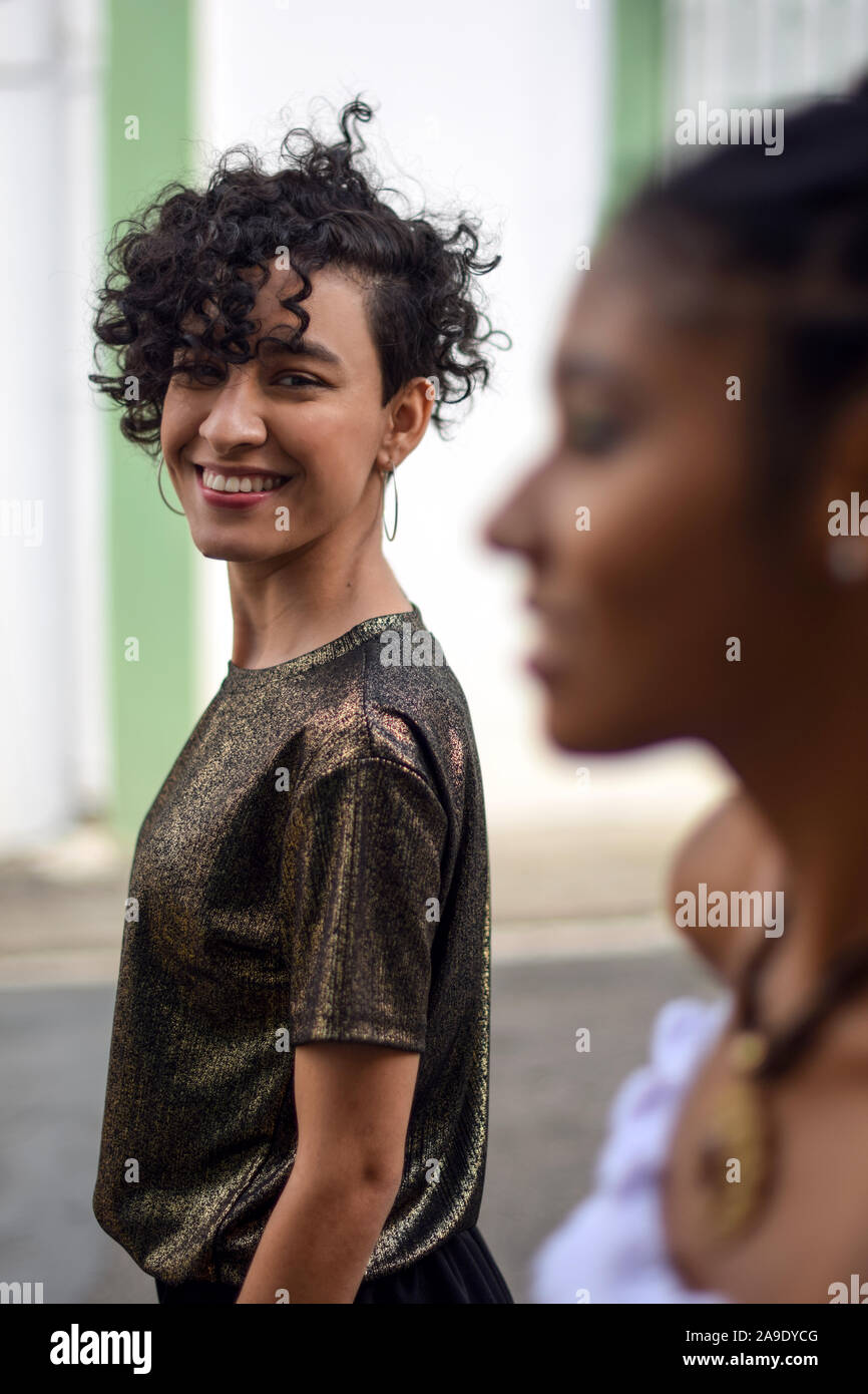 Two latin young women in the street; one looks at the camera, the other looks away, Cali, Colombia Stock Photo