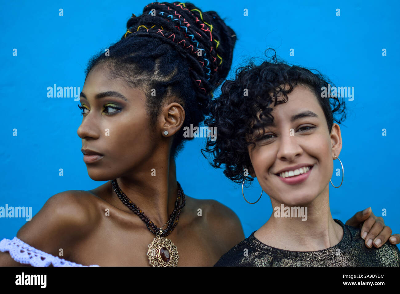 Two latin young women in the street; one looks at the camera, the other looks away, Cali