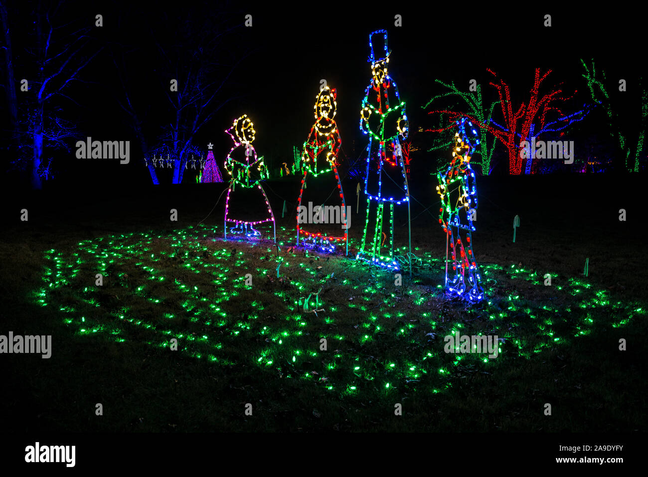 Xmas Carolers In Colorful Lights Night Green Grass Lights