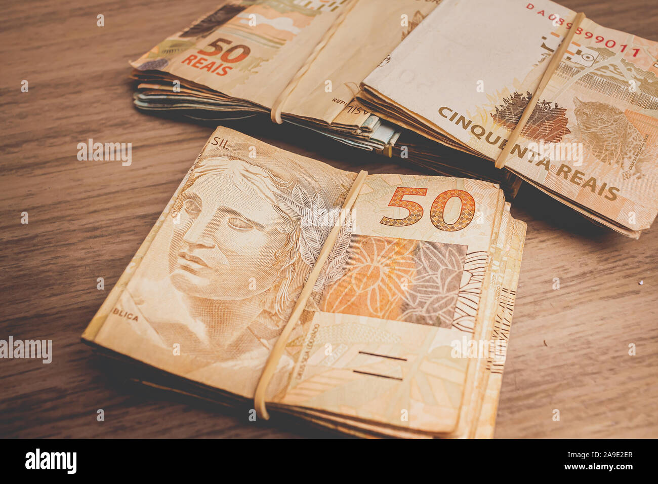 Brazilian Currency. Photo of a group of 50 reais notes on wooden furniture. Stock Photo
