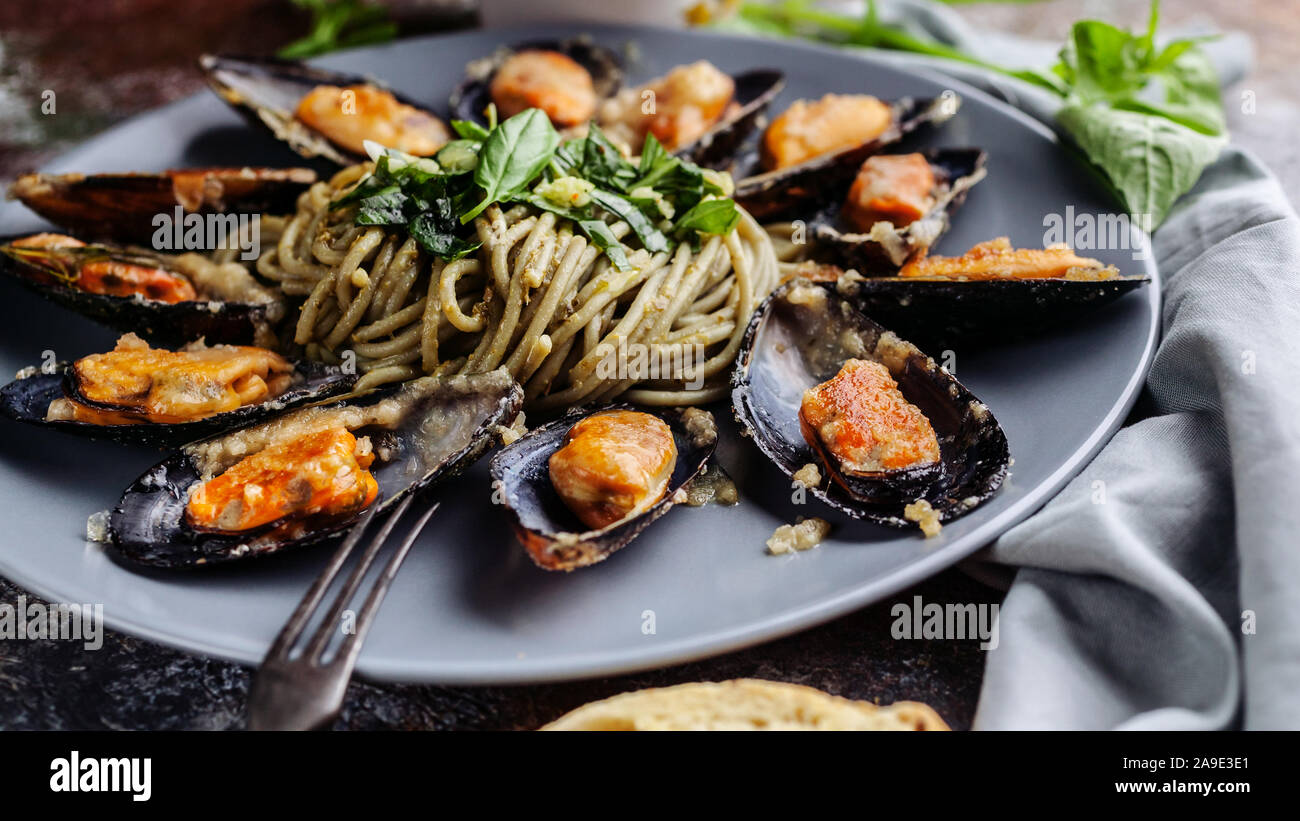 Food web banner Delicious seafood pasta. Fresh mussels and pesto pasta. Mediterranean Kitchen. Stock Photo