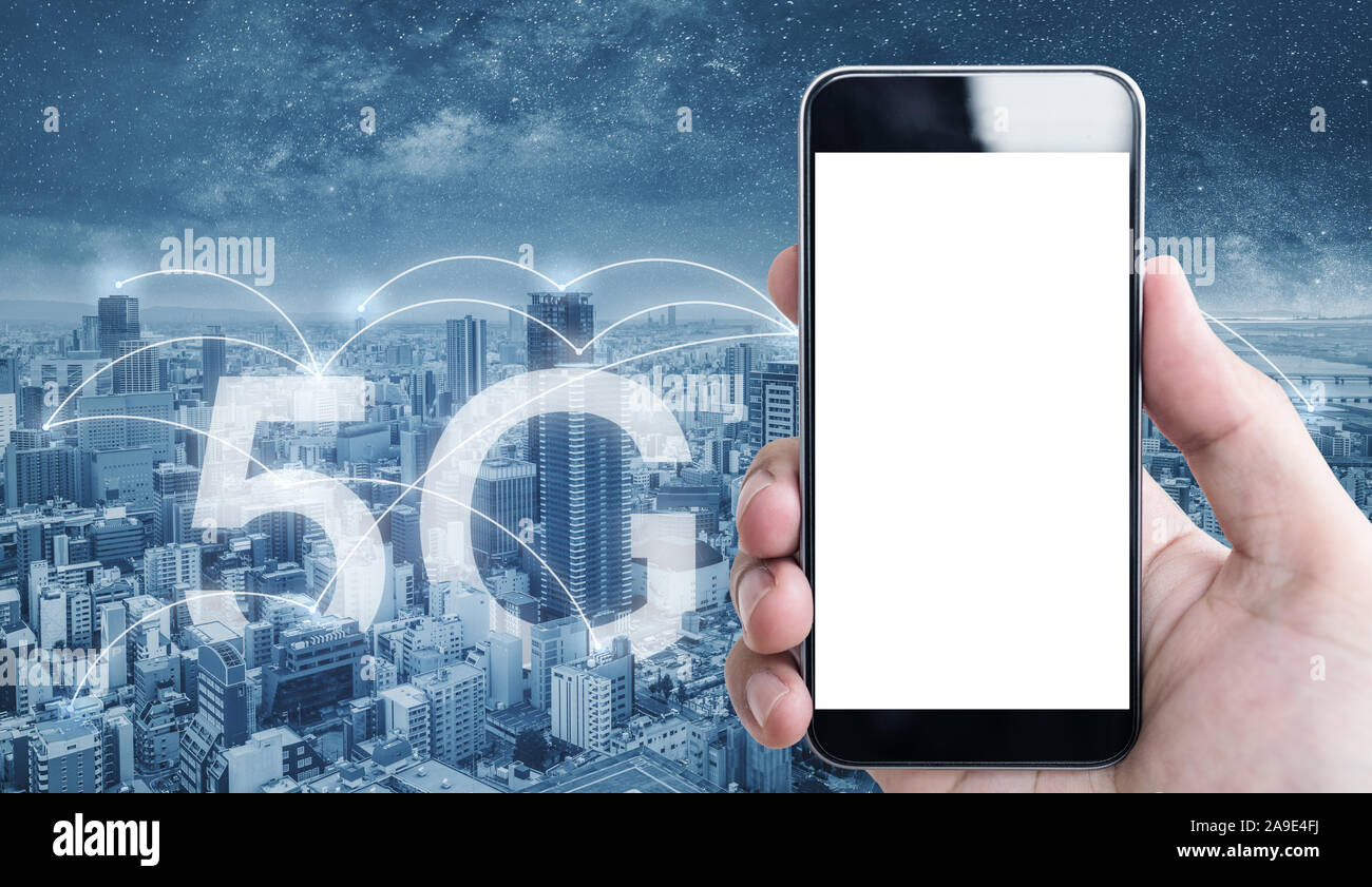Hand using mobile smart phone, blank white screen, with 5g internet networking in the city Stock Photo