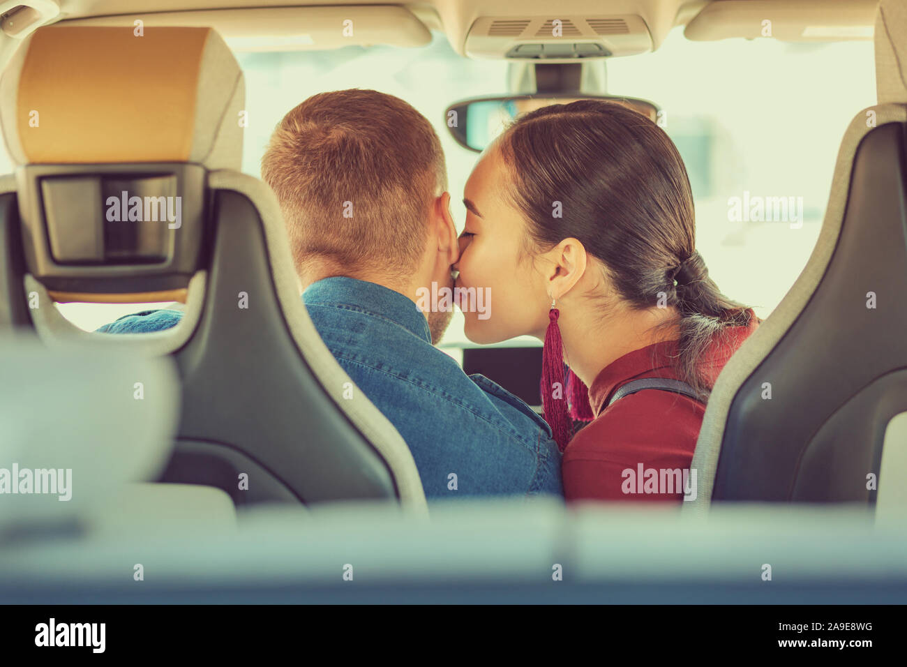 Tender Asian woman kissing her lovely boyfriend Stock Photo