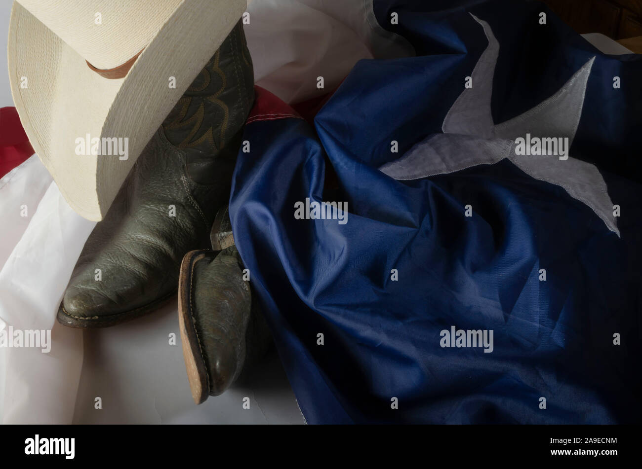 Cowboy hat and boots represent a way of life in the great state of Texas by resting on the Lone star state flag. Stock Photo