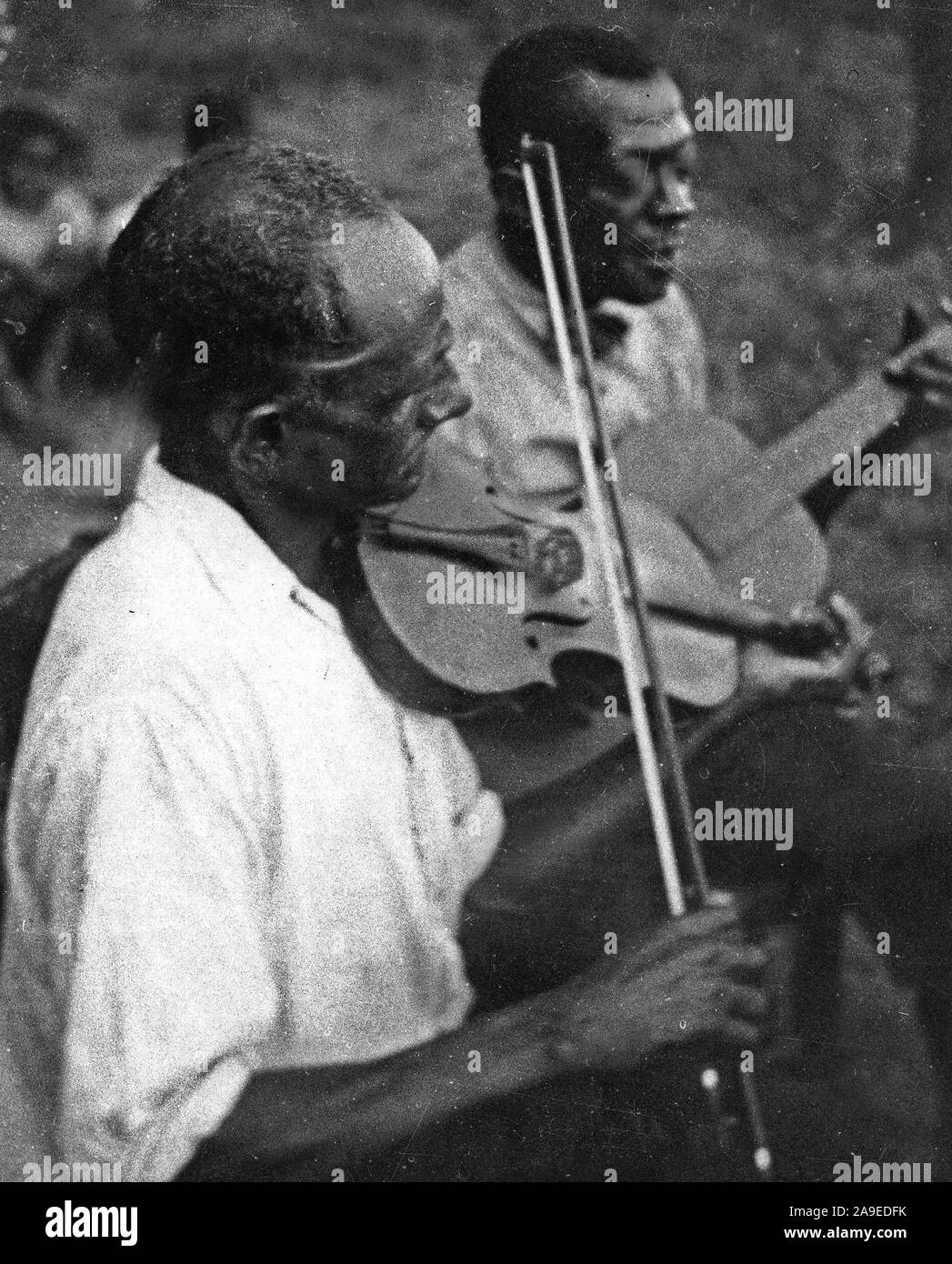 Stavin' Chain playing guitar and singing the ballad 'Batson' accompanied by a musician playing violin, Lafayette, La. ca. June 1934 Stock Photo