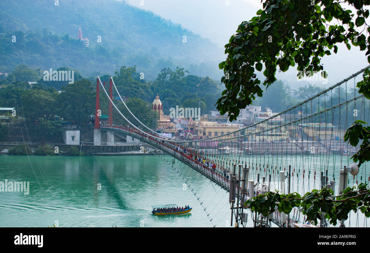 beautiful view of Rishikesh in India 'ram jhula' and 'lakshman jhula' suspension bridge beautiful scenery with boat in the river ganges in lake in the Stock Photo
