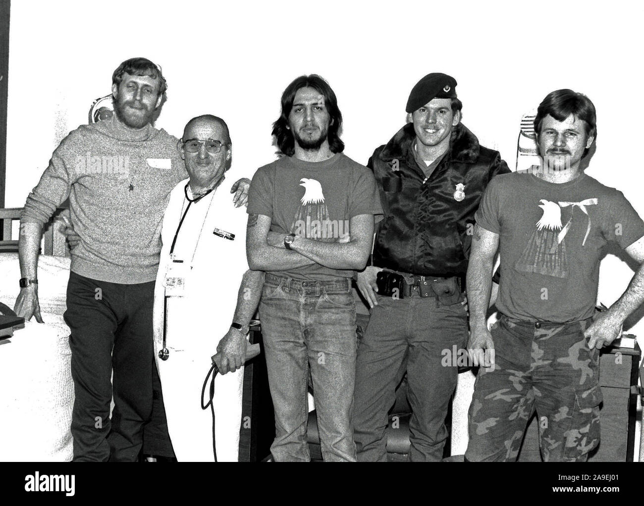 1981 - Former hostages U.S. Marine Corps SSGT Michael Moeller and SGT James Lopez, U.S. Air Force SRA Richard Jiran, and U.S. Marine Corps SGT Paul Lewis, left to right, pose with a nurse. Stock Photo
