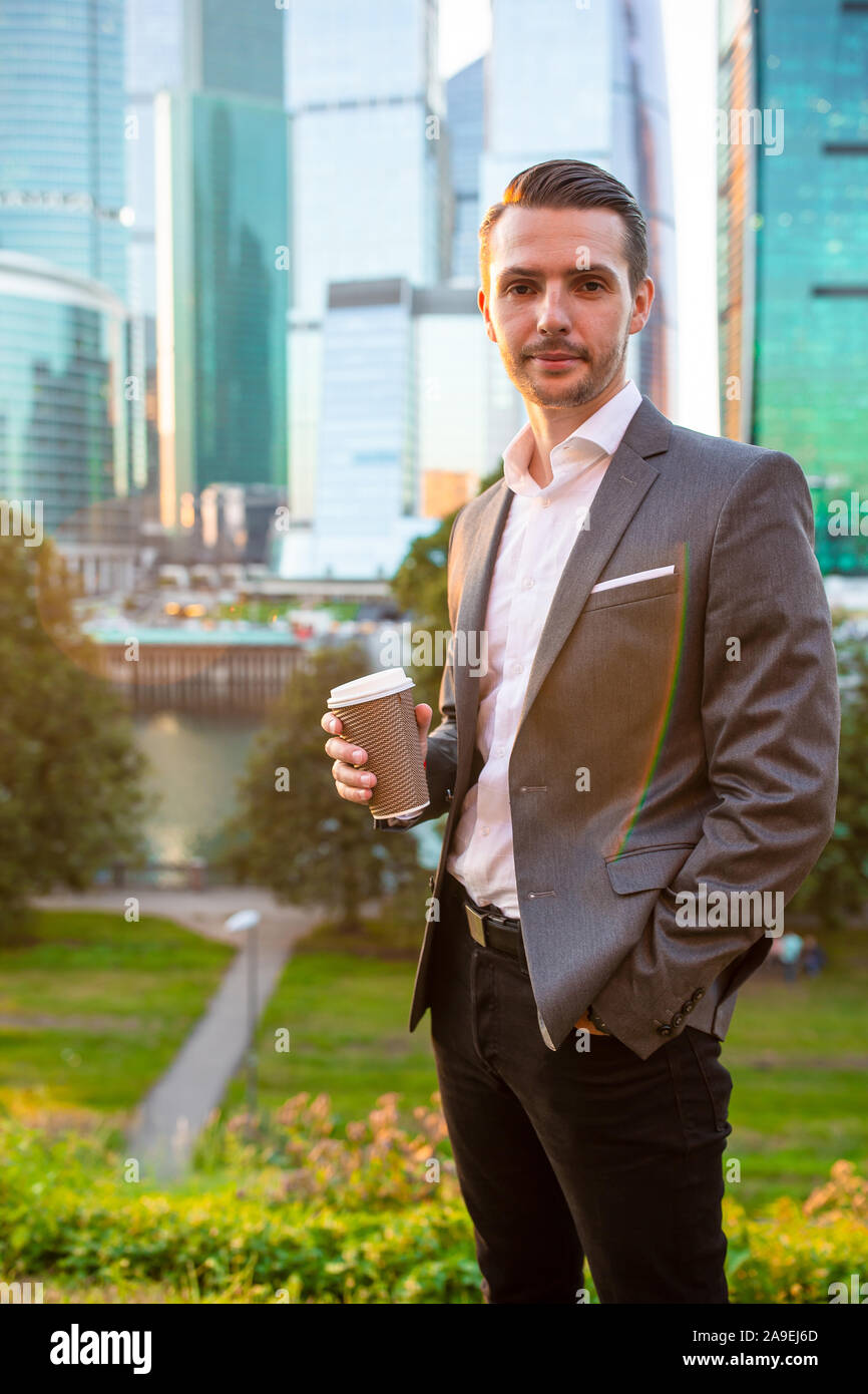 Businessman in urban city with skyscrapers buildings in the with coffee ...