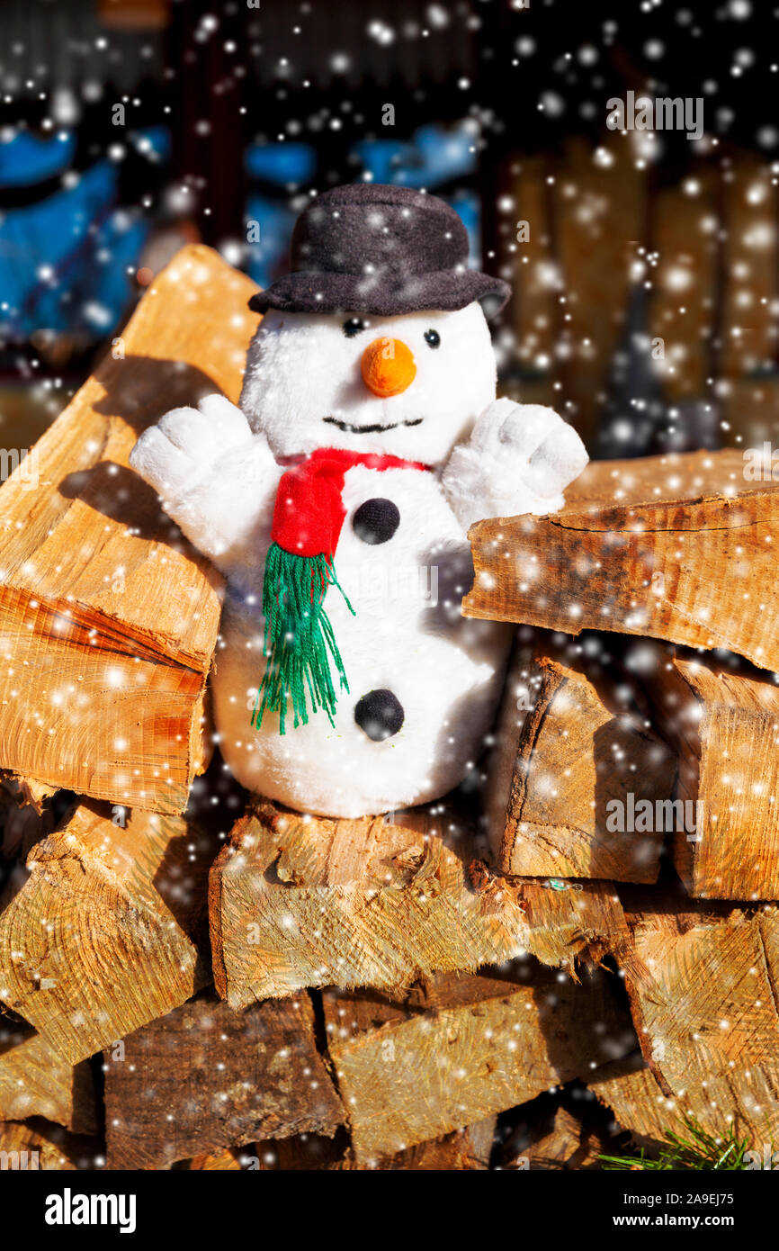 Plush snowman on woodpile Stock Photo - Alamy