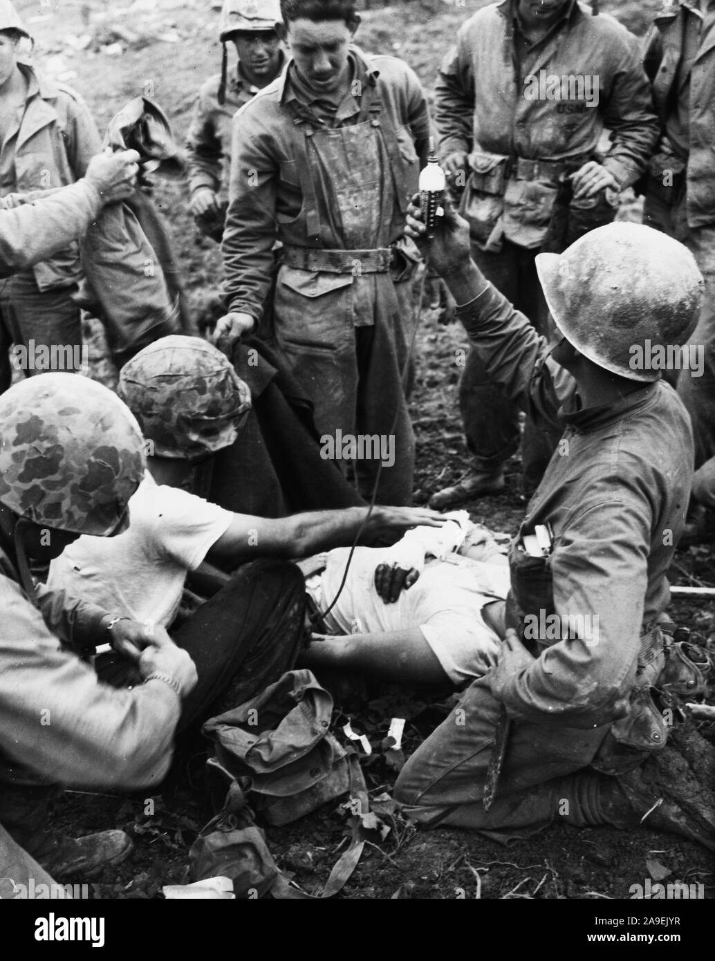 Wounded soldier on Okinawa being administered blood plasma Stock Photo