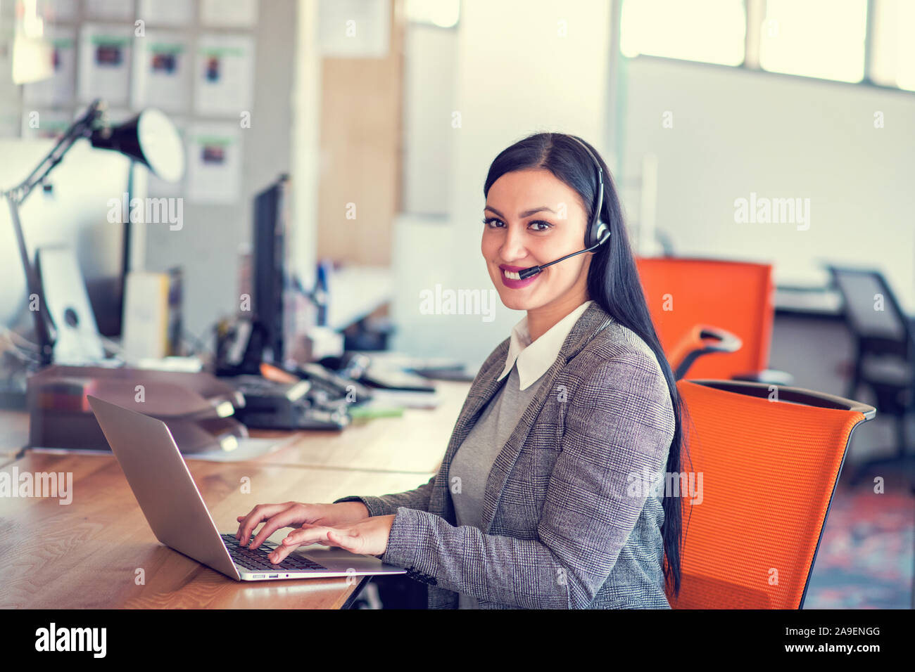 Beautiful call center agent browsing the internet on her computer Stock Photo