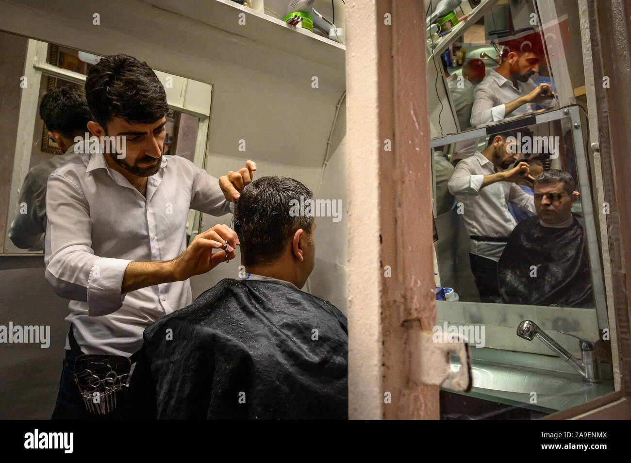 A barber cutting hair near the Grand Bazaar, Istanbul, Turkey Stock Photo