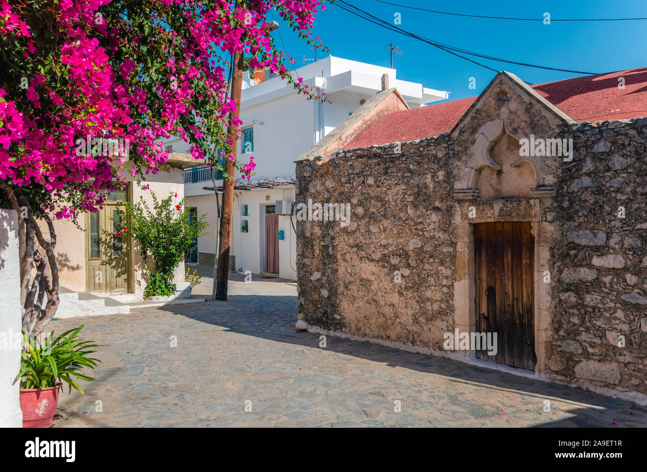 Kritsa traditional cretan village with stone built church, narrow alley and houses with bougainvilleas, near Agios Nikolaos. Crete, Greece Stock Photo