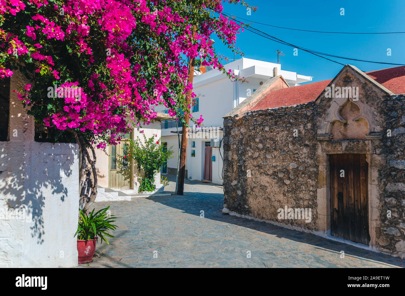 Kritsa traditional cretan village with stone built church, narrow alley and houses with bougainvilleas, near Agios Nikolaos. Crete, Greece Stock Photo