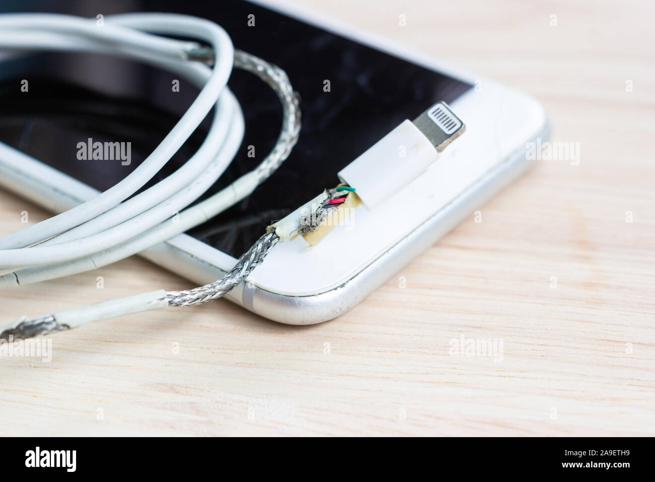 unsafe cable Phone Charger Lack of damage on white background Stock