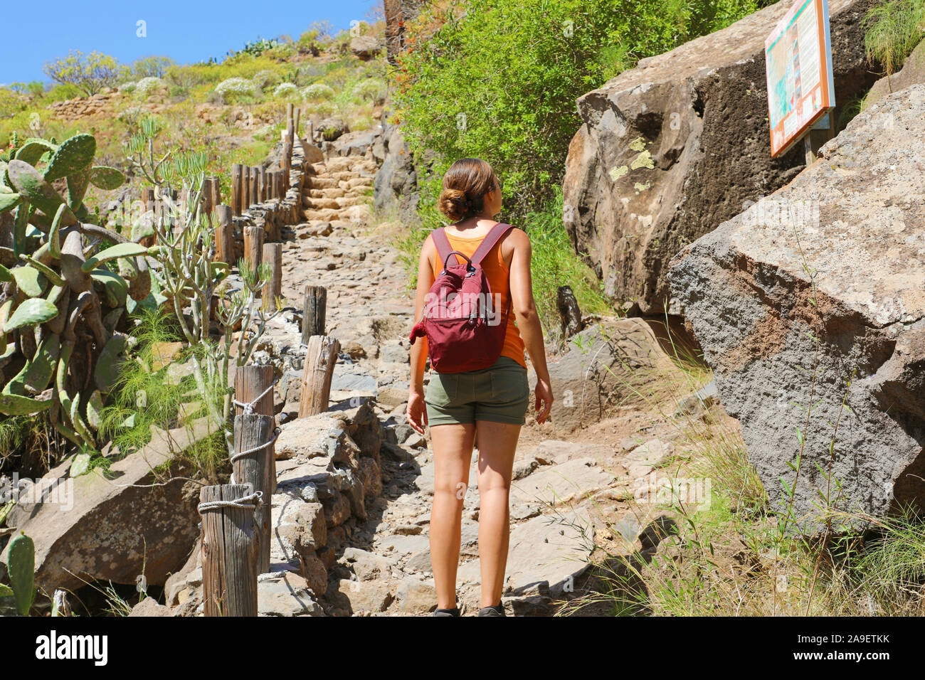 Tourist girl backpacker reading map on the tourist path in Tenerife, Canary Islands, Spain. Stock Photo
