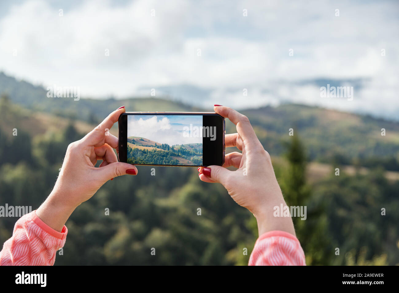 Woman taking picture in mountains using smart photne Stock Photo