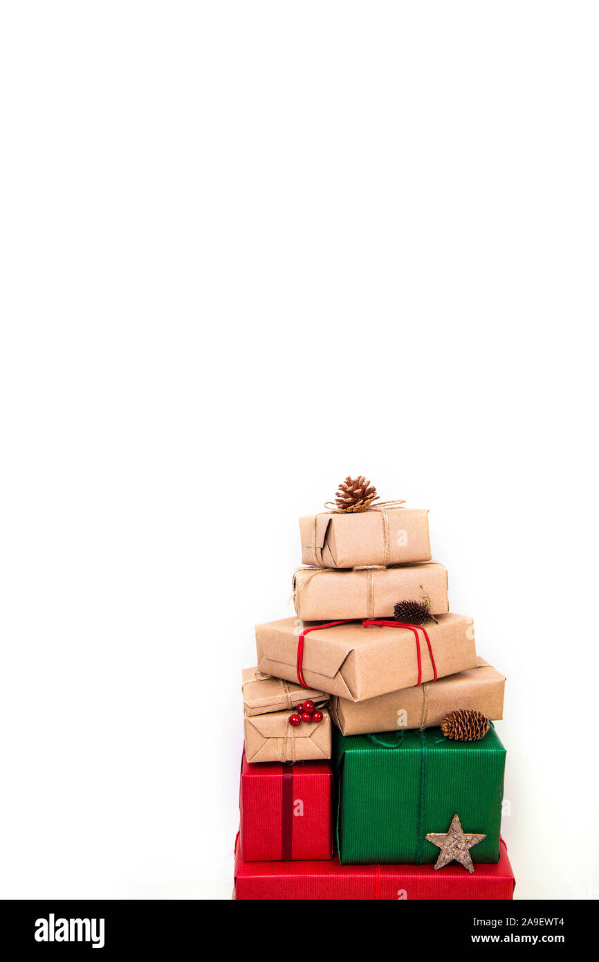 A pile of Christmas gifts in red, green and natural wrapping with ...