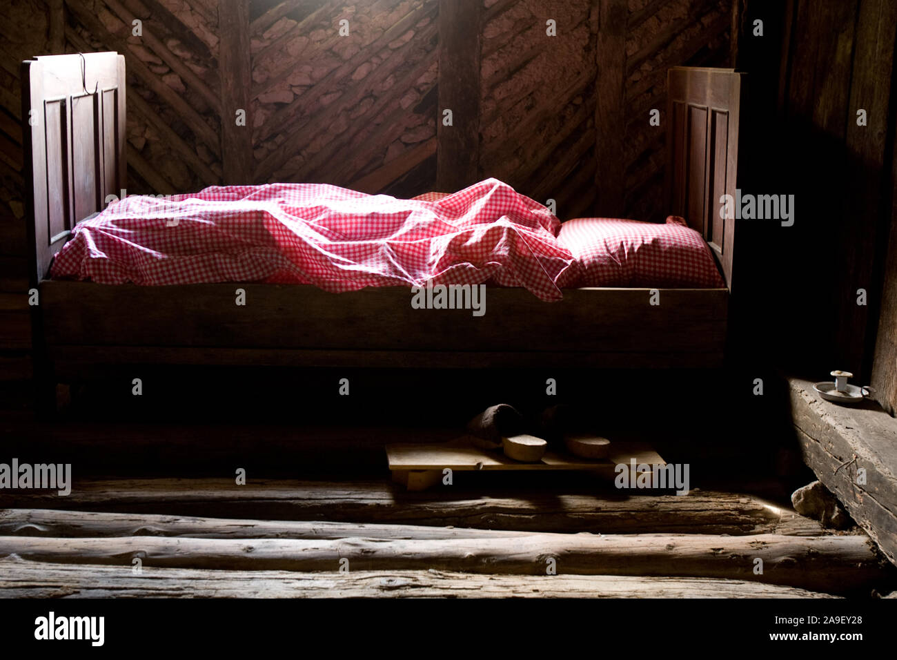 Kropa, Slovenia, July 4, 2008: An old bed in the attic of an old ironworkers house turned into a museum in Kropa, Slovenia. Stock Photo