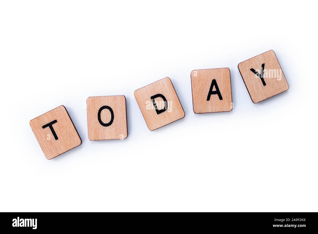 The word TODAY, spelt with wooden letter tiles over a white background. Stock Photo