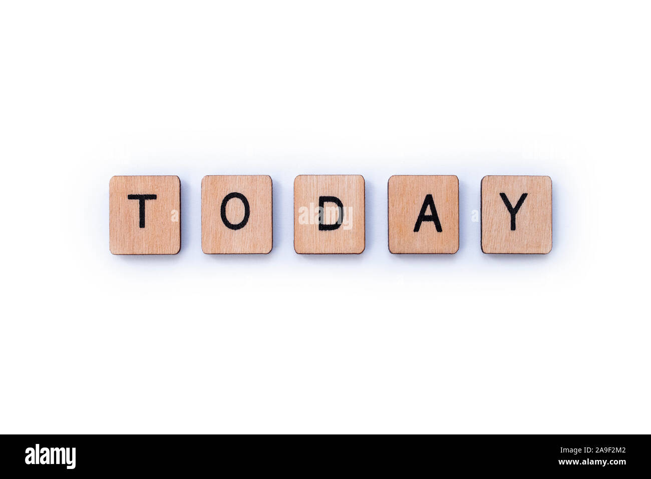 The word TODAY, spelt with wooden letter tiles over a white background. Stock Photo