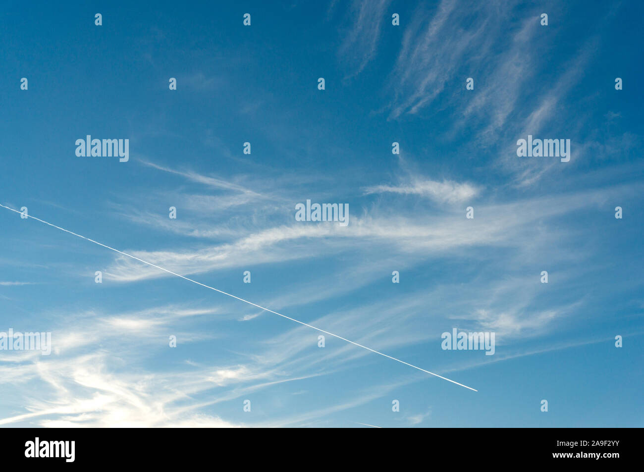 Abstract sky background with airplane contrail, trail and light clouds. Minimalistic nature background Stock Photo