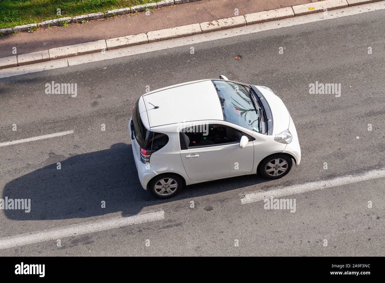 Nice, France - August 13, 2018: White Toyota iQ is on the road at sunny day, top view. It is a transverse engined, front-wheel-drive compact city car Stock Photo