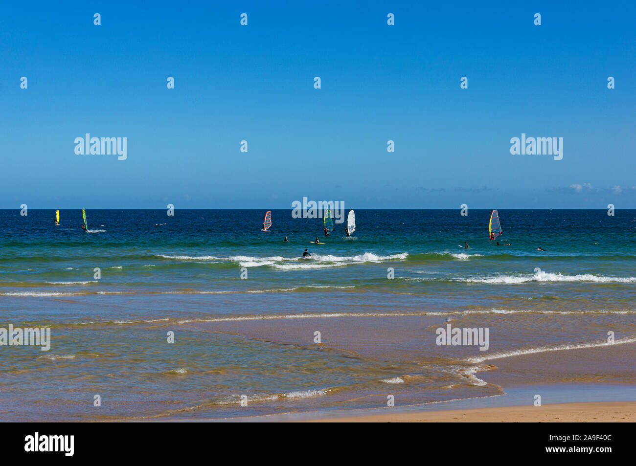 Windsurfers surfing ocean waves on sunny day. AUstralia Stock Photo