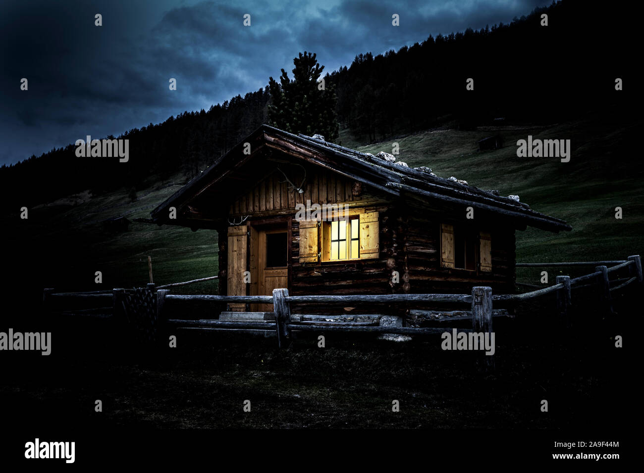 Alpine hut with enlightened window Stock Photo