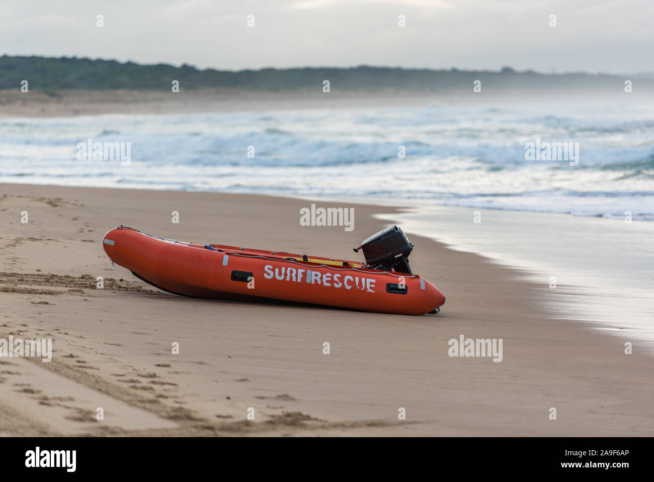 Bright orange surf saver boat on sandy beach shore. Cronulla, Australia Stock Photo
