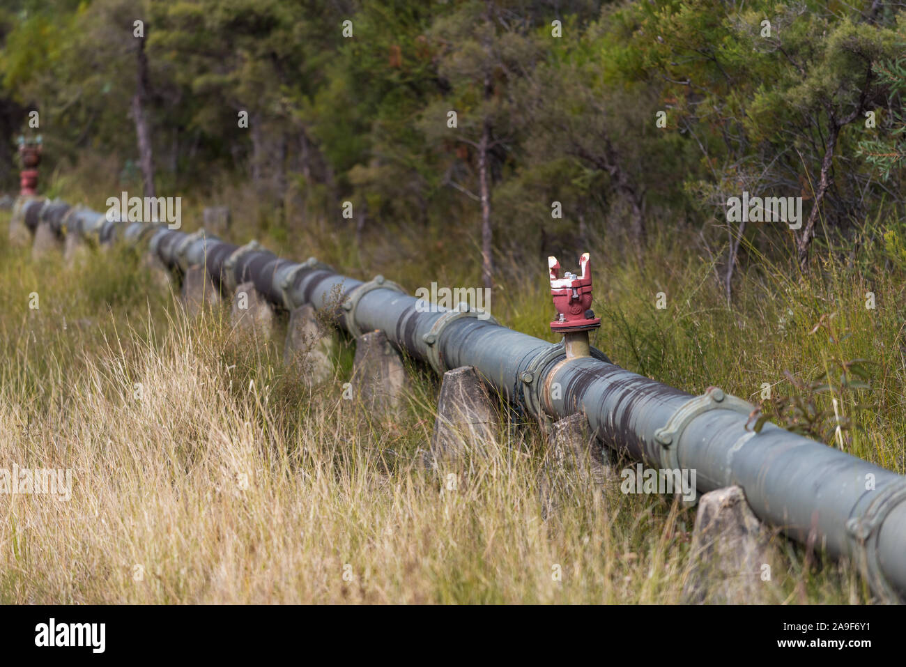 Outdoor trunk pipeline with metal fittings and valve. Rural