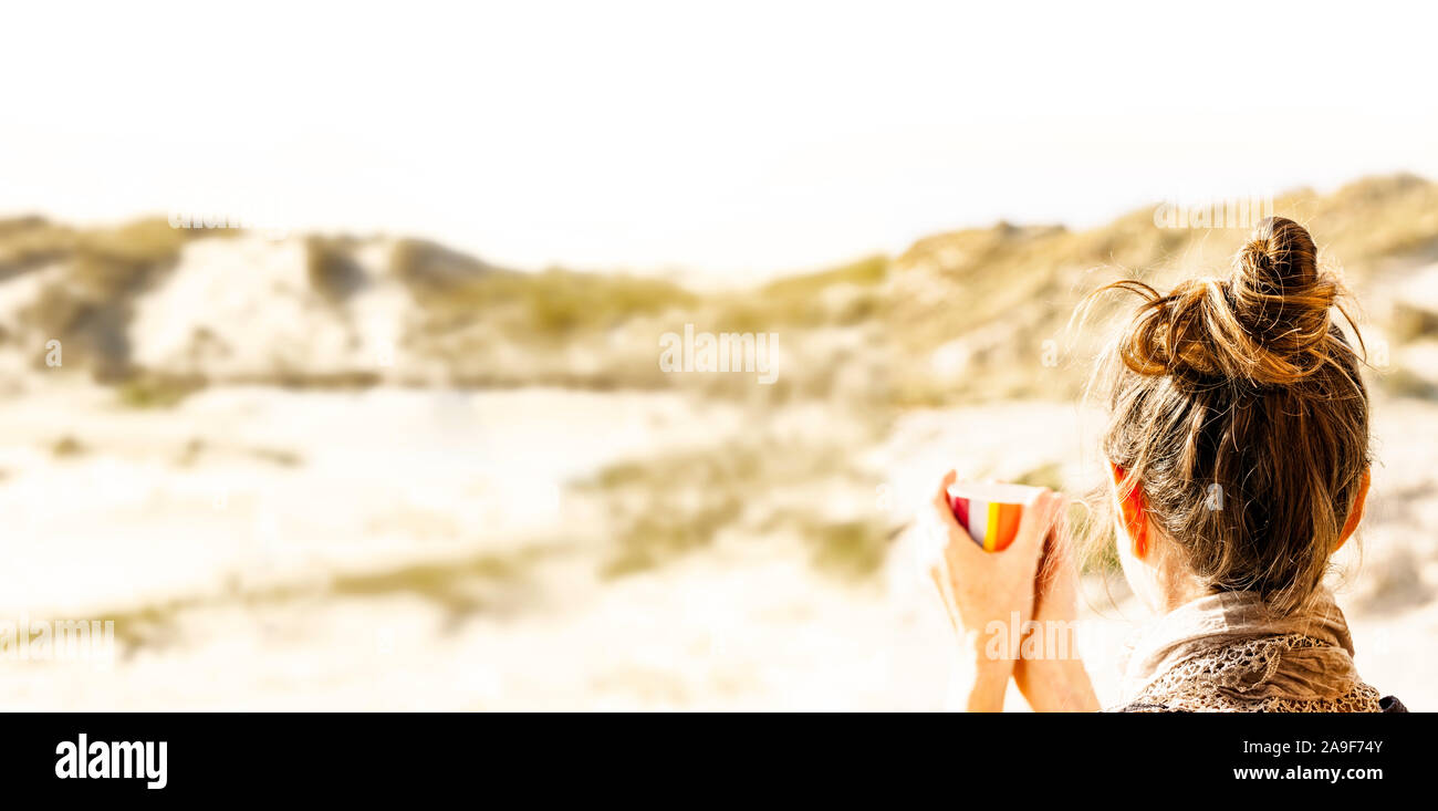 Woman with cup in dunes Stock Photo