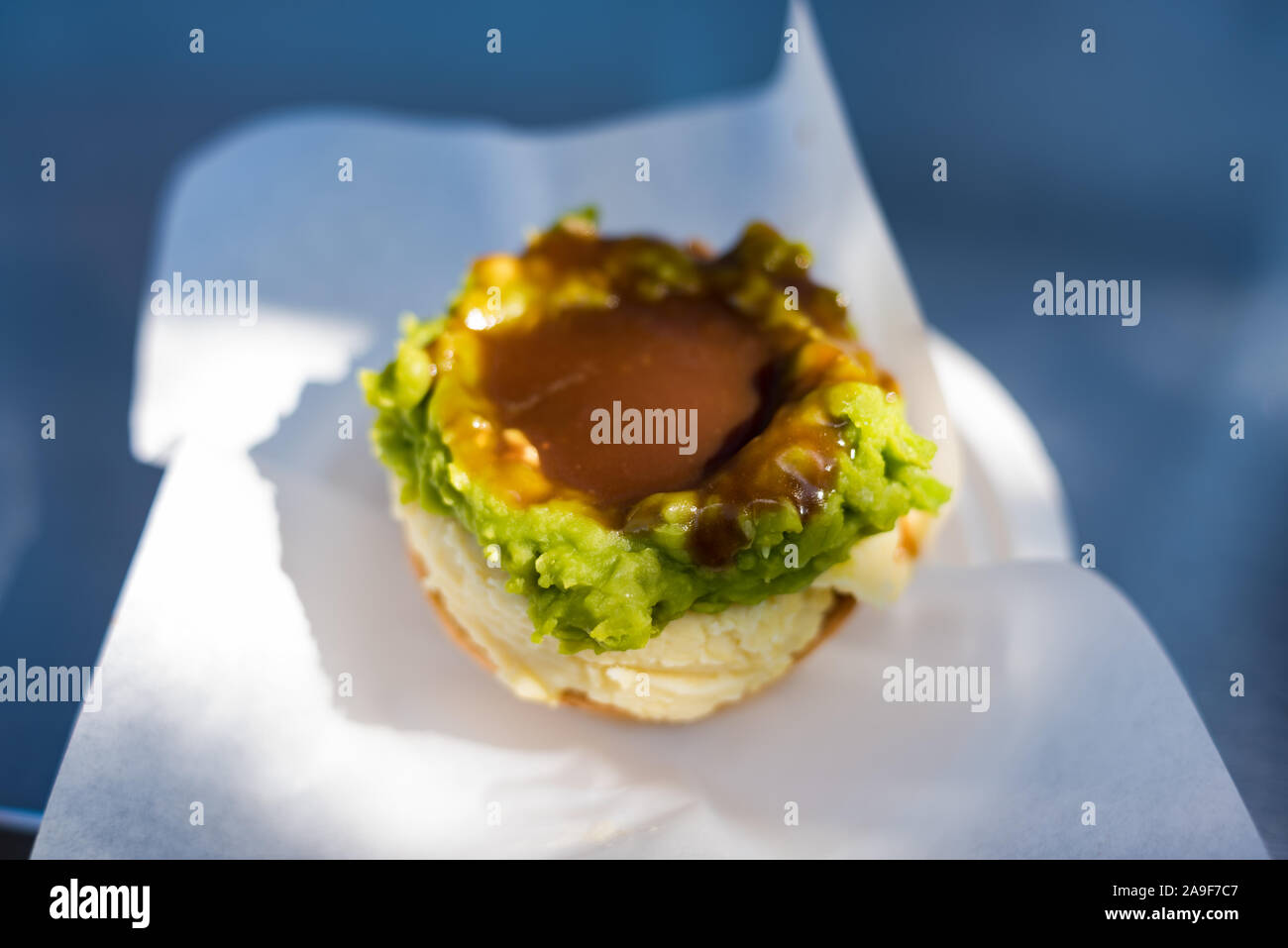 Australian traditional meat pie with mashed potatoes, green peas and gravy in pastry case Stock