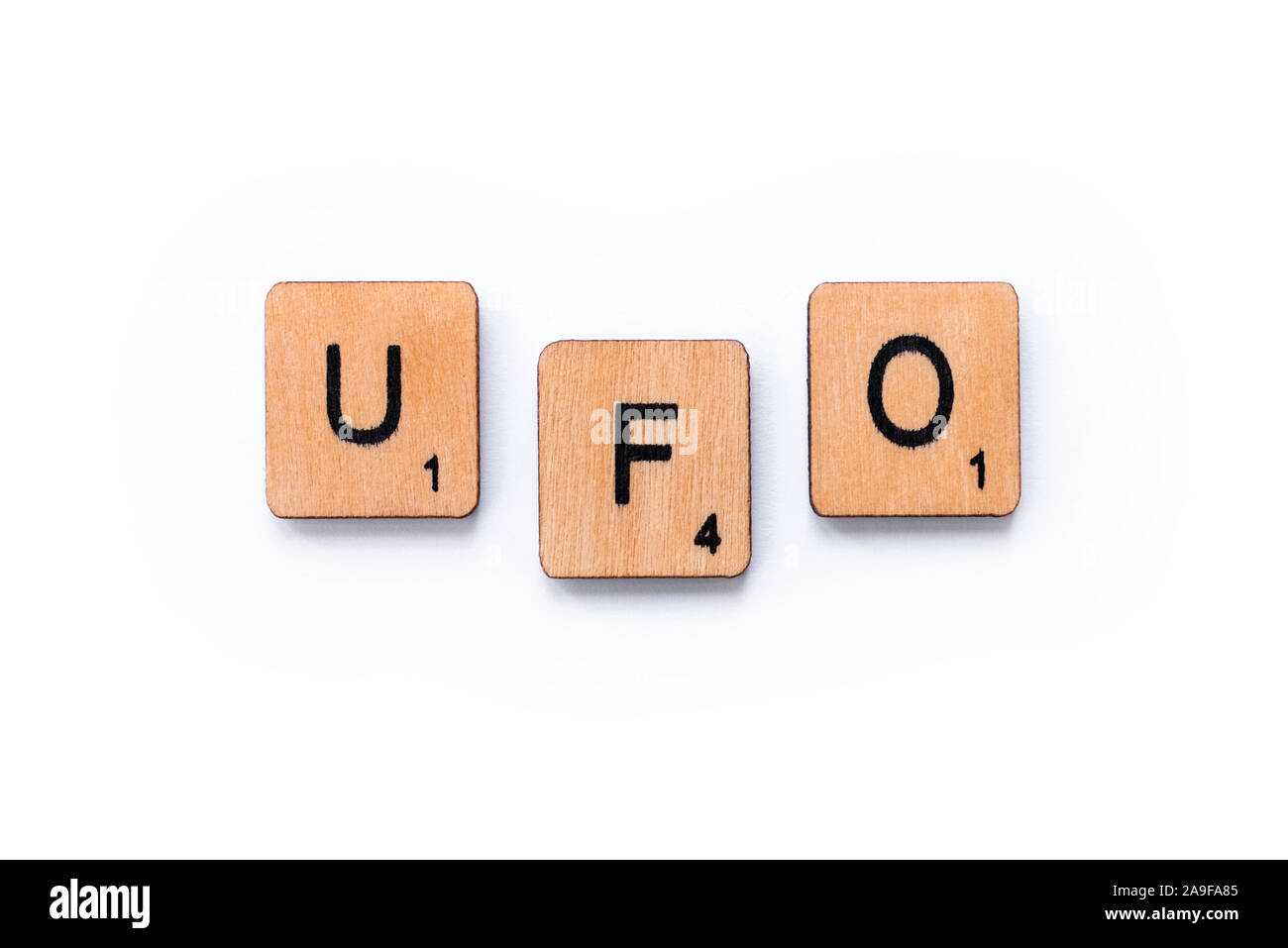 London, UK - June 12th 2019: The abbreviation UFO which stands for Unidentified Flying Object, spelt with wooden letter tiles over a white background. Stock Photo