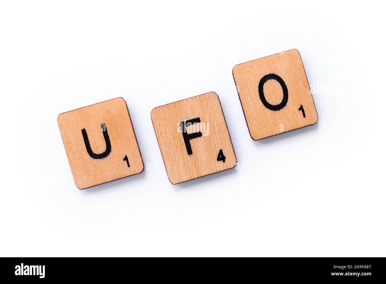 London, UK - June 12th 2019: The abbreviation UFO which stands for Unidentified Flying Object, spelt with wooden letter tiles over a white background. Stock Photo