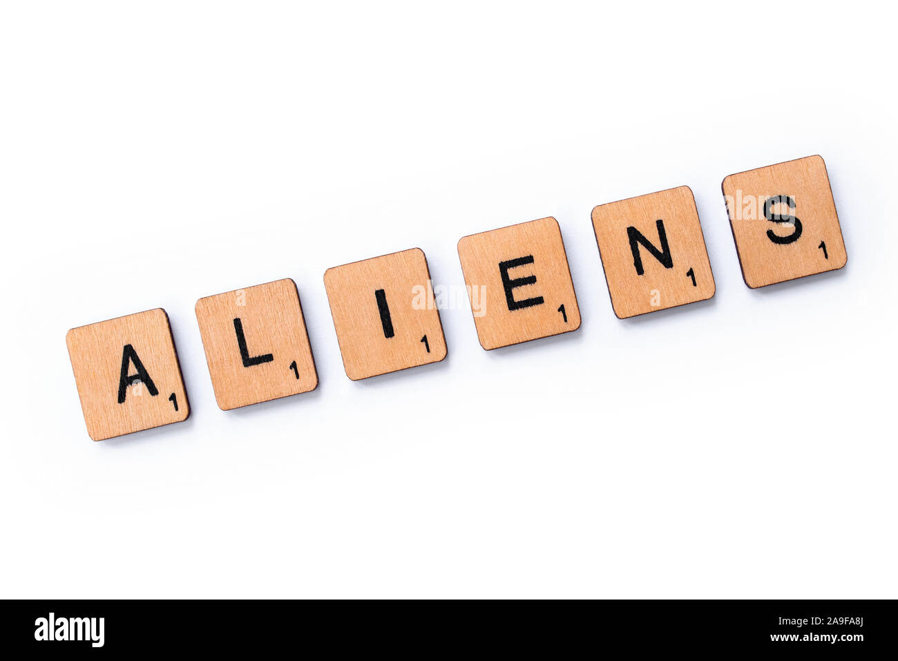 London, UK - June 12th 2019: The word ALIENS, spelt with wooden letter tiles over a white background. Stock Photo