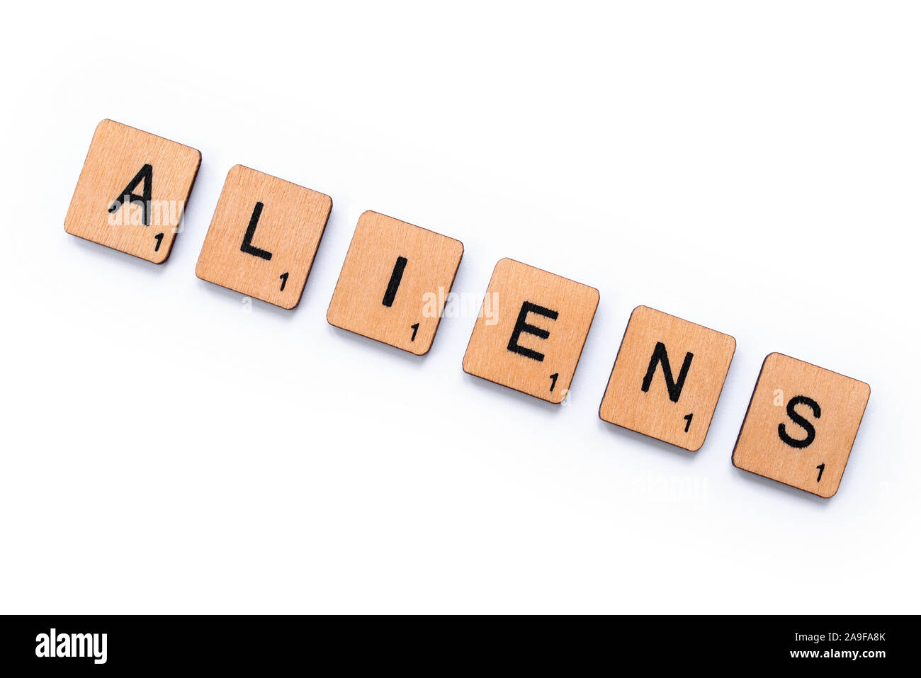 London, UK - June 12th 2019: The word ALIENS, spelt with wooden letter tiles over a white background. Stock Photo